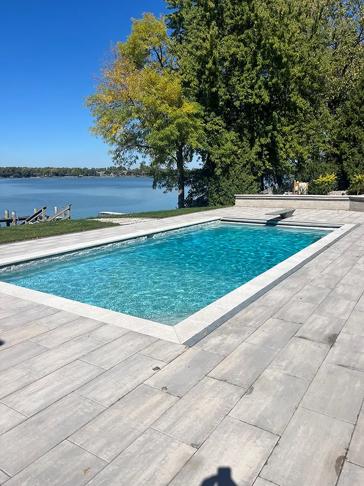 pool in front of lake with diving board